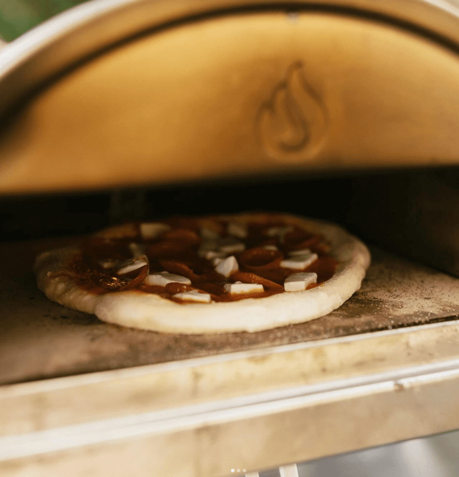 A pizza going into the stone oven